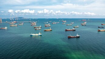 A view of many oil and gas tankers at anchor in a bay.