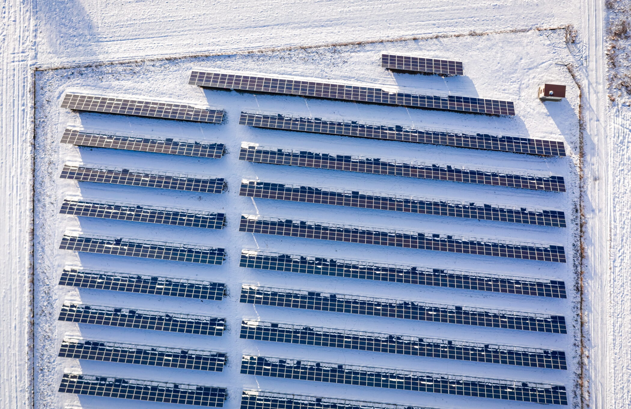 Aerial view of a solar farm in Poland in winter, surrounded by snow. Even in winter, solar PV contributes to Poland's energy mix.