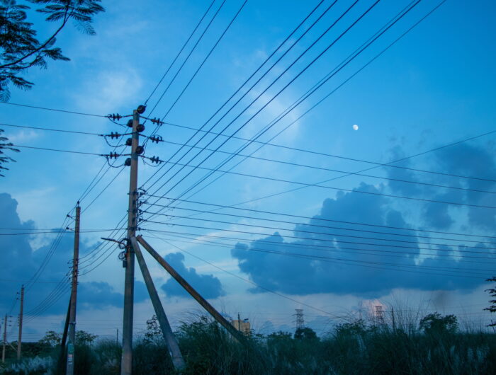 Overhead energy power lines in Bangladesh against a dark blue sky. The country is facing an energy crisis, impacting power generation, as conflict in the Middle East blocks fuel imports.